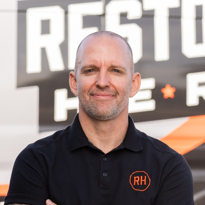 Adam Redhead in front of a Restoration Heroes van